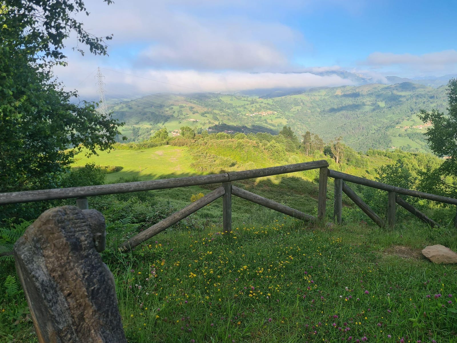 Mirador del Pico Llamadera con una valla de madera y vistas a los valles verdes